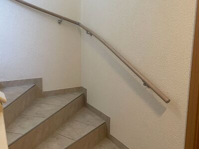 Eleganter Handlauf an einer gewendelten Treppe in Waltenschwil in beigefarbener Optik